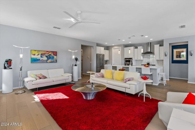 living room with ceiling fan and light hardwood / wood-style floors