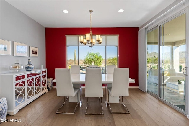 dining space with hardwood / wood-style flooring and a notable chandelier