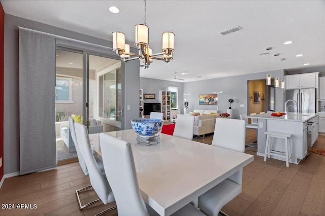 dining area with a chandelier and light hardwood / wood-style flooring