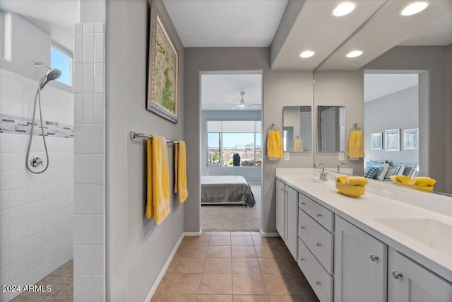 bathroom with tiled shower, vanity, ceiling fan, and tile patterned floors