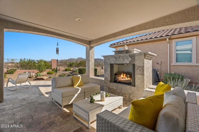 view of patio / terrace with a mountain view and an outdoor living space with a fireplace