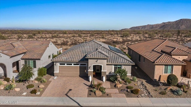 view of front of home with a mountain view and a garage