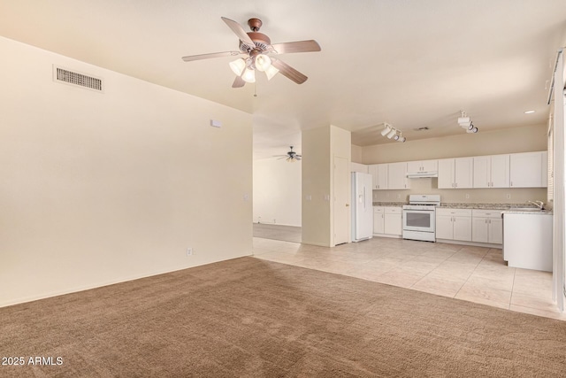 unfurnished living room featuring light tile patterned floors, ceiling fan, and sink