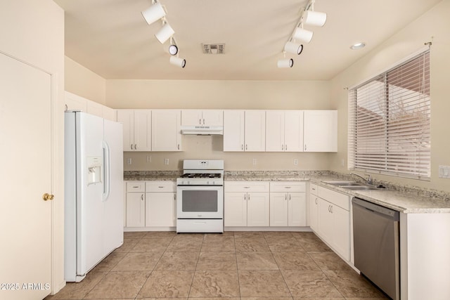 kitchen featuring track lighting, white appliances, sink, light tile patterned floors, and white cabinetry