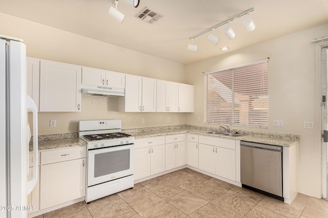 kitchen featuring light stone counters, white appliances, sink, light tile patterned floors, and white cabinetry