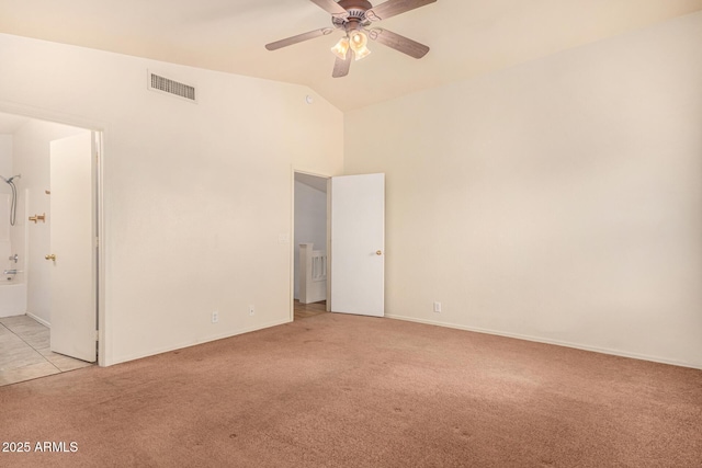 carpeted spare room featuring ceiling fan and vaulted ceiling