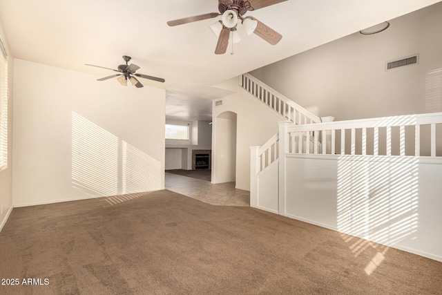 unfurnished living room featuring carpet floors and ceiling fan