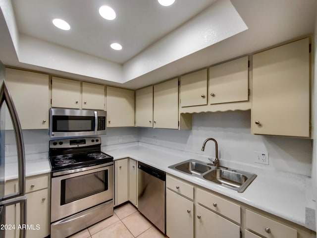 kitchen featuring light tile patterned floors, light countertops, appliances with stainless steel finishes, and a sink