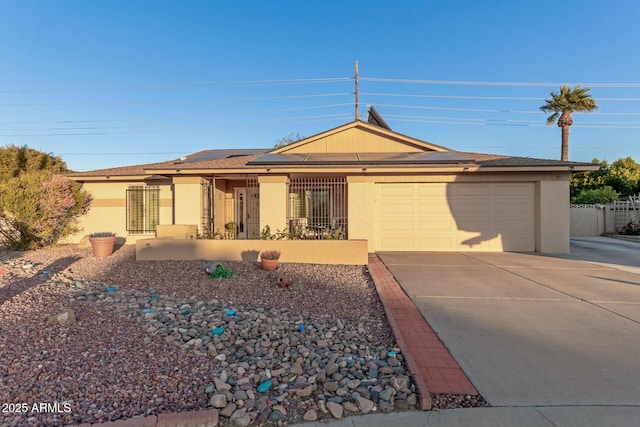 single story home featuring solar panels, a garage, driveway, and stucco siding