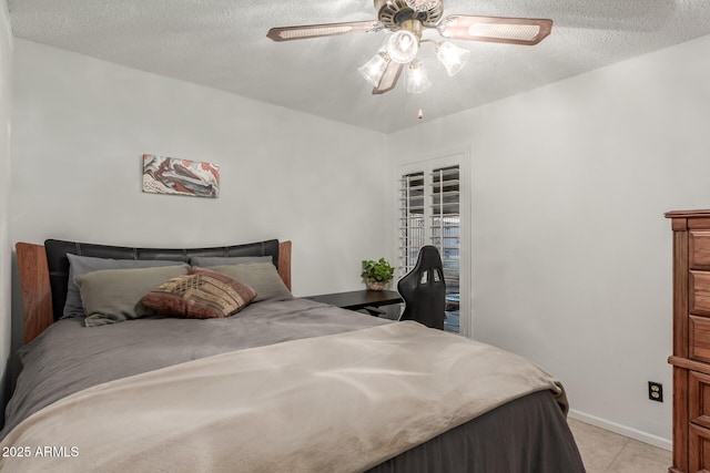 bedroom with light tile patterned floors, baseboards, a textured ceiling, and a ceiling fan