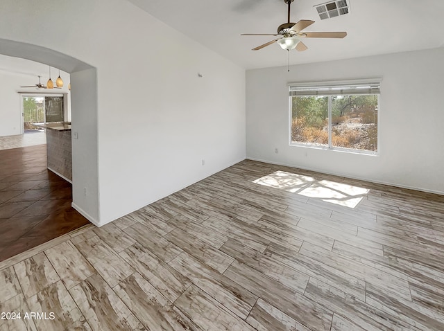 spare room with a healthy amount of sunlight, light hardwood / wood-style floors, and ceiling fan