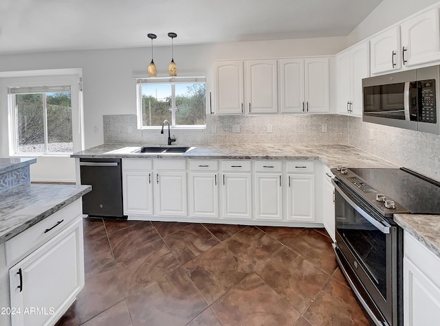 kitchen with hanging light fixtures, white cabinetry, and stainless steel appliances