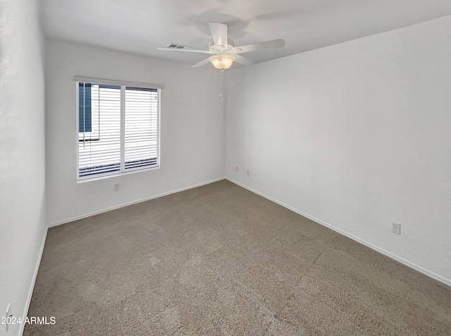 carpeted spare room with ceiling fan