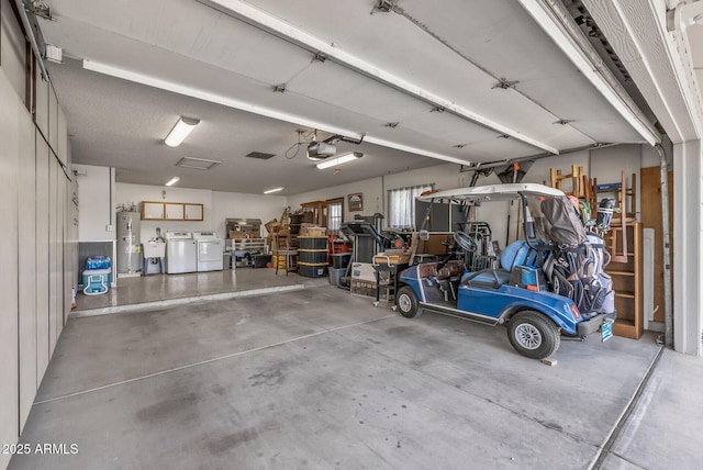 garage with water heater, a garage door opener, a sink, and washing machine and clothes dryer