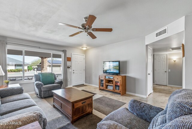 living room featuring a ceiling fan, visible vents, and baseboards