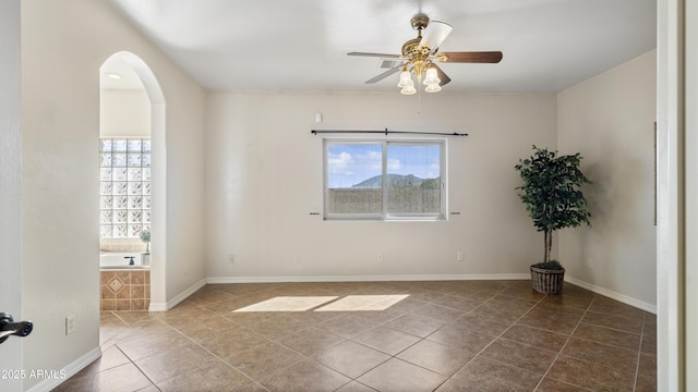 tiled spare room with plenty of natural light and ceiling fan