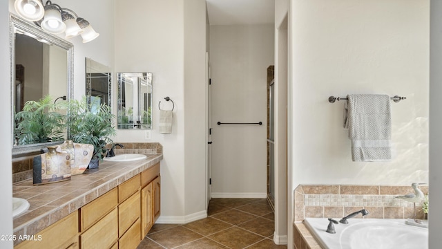 bathroom featuring tile patterned flooring, vanity, and tiled tub