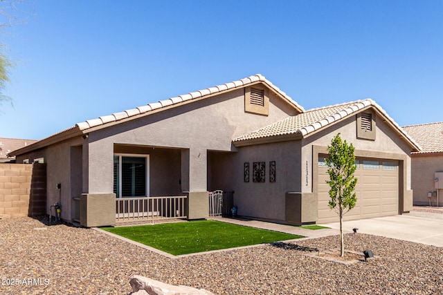 view of front of house with driveway, an attached garage, fence, and stucco siding