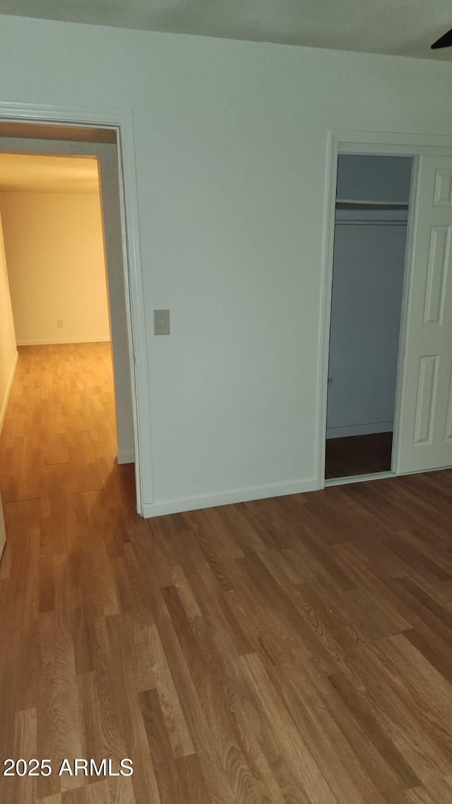 unfurnished bedroom featuring a closet and hardwood / wood-style flooring