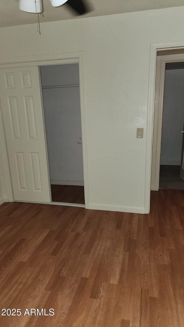 unfurnished bedroom with a closet and wood-type flooring