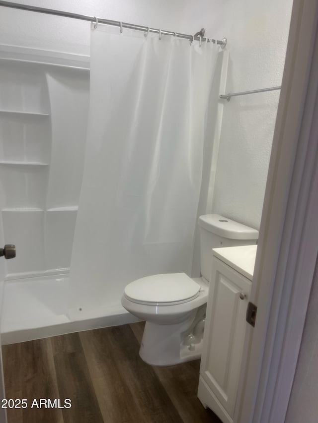 bathroom featuring toilet, wood-type flooring, vanity, and a shower with shower curtain