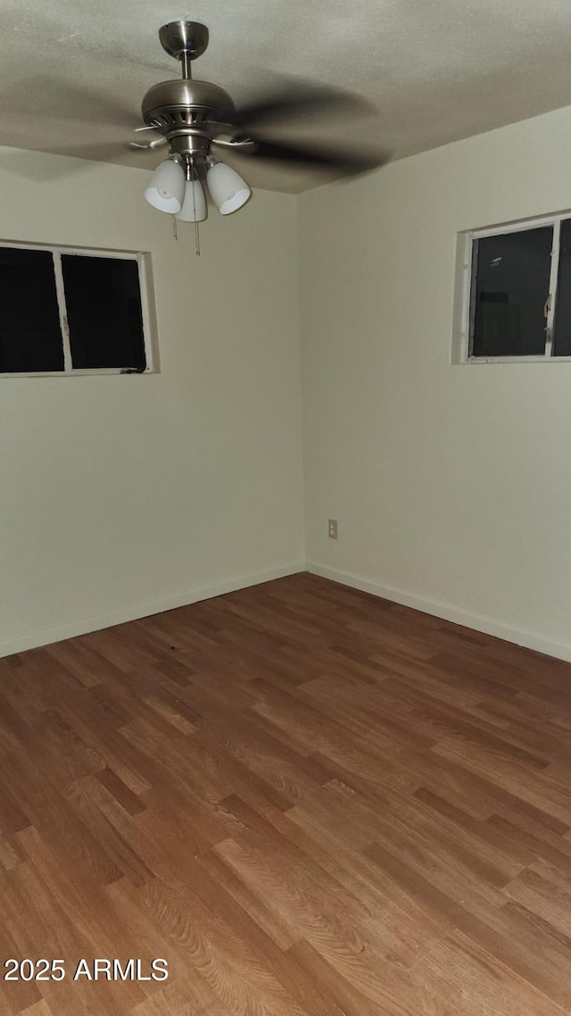 spare room with ceiling fan and hardwood / wood-style flooring