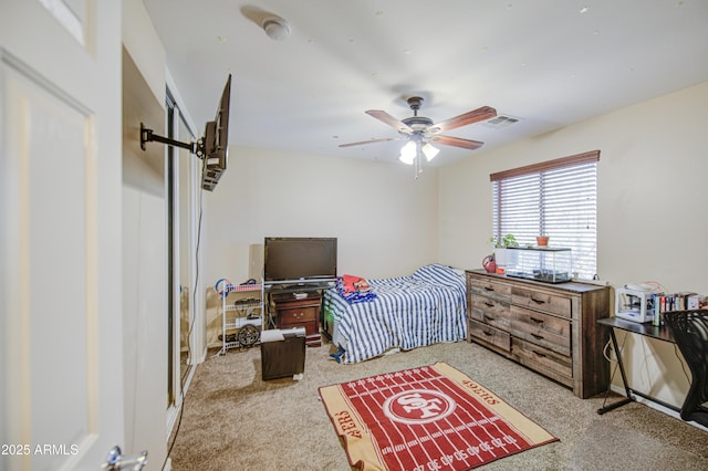 carpeted bedroom with a ceiling fan and visible vents