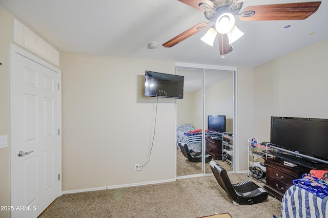 carpeted bedroom with a closet, baseboards, and a ceiling fan