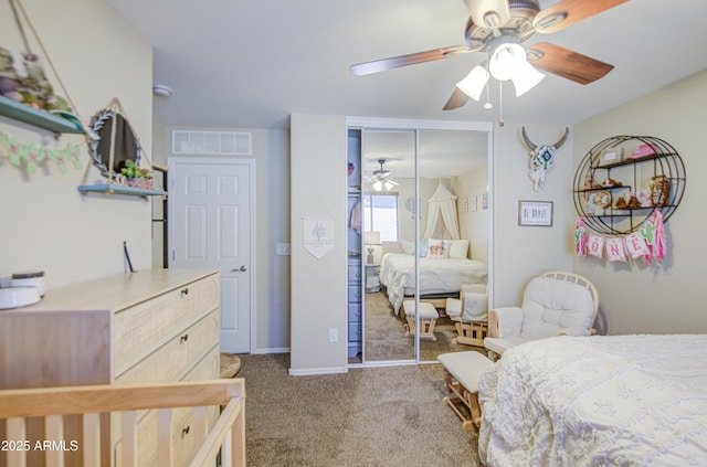 carpeted bedroom with visible vents, a closet, baseboards, and ceiling fan