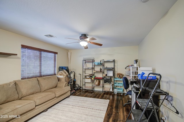 living room with visible vents, ceiling fan, and hardwood / wood-style flooring