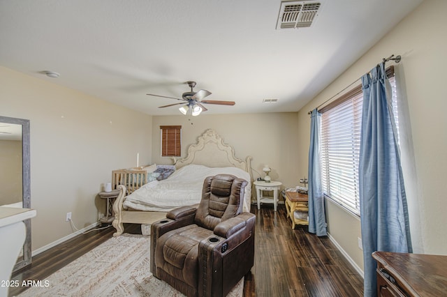 bedroom with ceiling fan, visible vents, baseboards, and wood finished floors