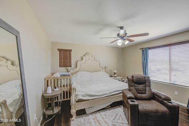 bedroom with ceiling fan, baseboards, and wood finished floors