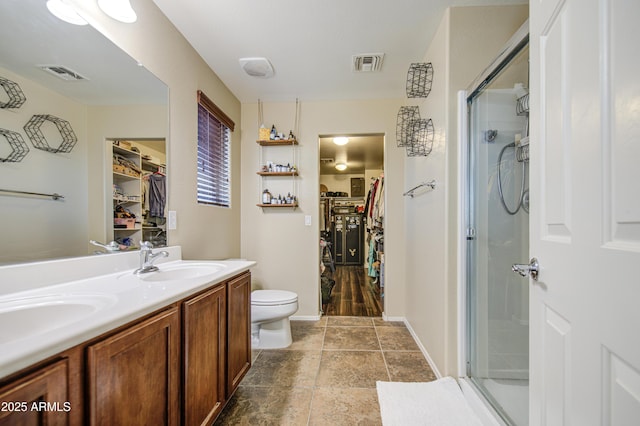 bathroom with a shower stall, visible vents, a sink, and toilet