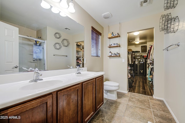 bathroom with a sink, visible vents, toilet, and a stall shower