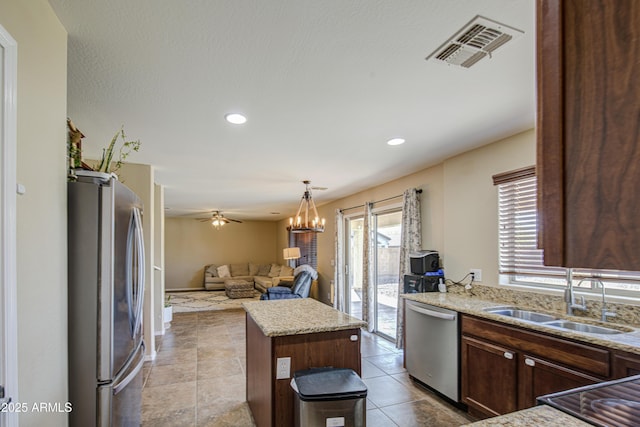 kitchen featuring open floor plan, a center island, visible vents, stainless steel appliances, and a sink