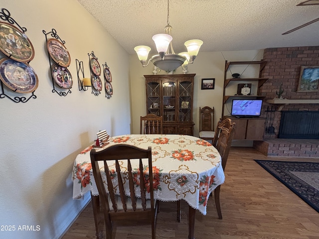 dining space with a chandelier, hardwood / wood-style floors, and a textured ceiling