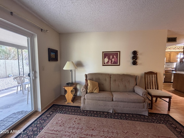 living room with hardwood / wood-style floors and a textured ceiling