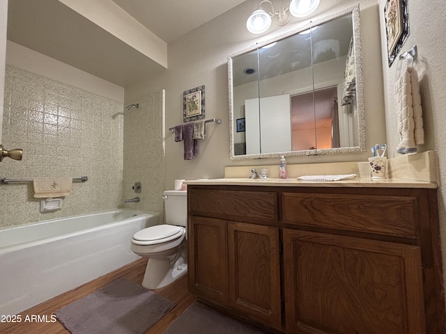 full bathroom featuring toilet, vanity, hardwood / wood-style floors, and tiled shower / bath