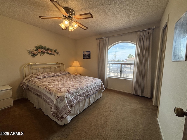 bedroom featuring ceiling fan, dark carpet, and a textured ceiling