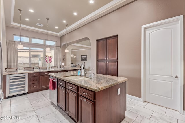 30056 N 129th Ave, Peoria, AZ 85383 - kitchen featuring sink, a kitchen island with sink, light stone counters, ornamental molding, and beverage cooler