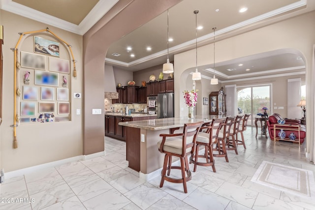 30056 N 129th Ave, Peoria, AZ 85383 - kitchen with stainless steel fridge, hanging light fixtures, ornamental molding, light stone countertops, and dark brown cabinets