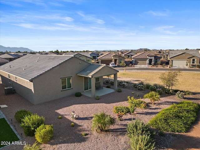 back of property with central AC, a patio area, and a mountain view