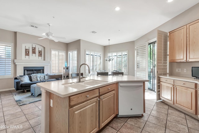 kitchen with a center island with sink, sink, white dishwasher, hanging light fixtures, and light brown cabinets