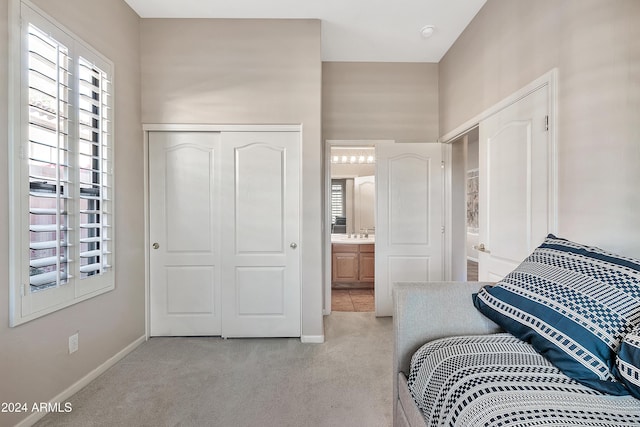 carpeted bedroom with a closet and connected bathroom