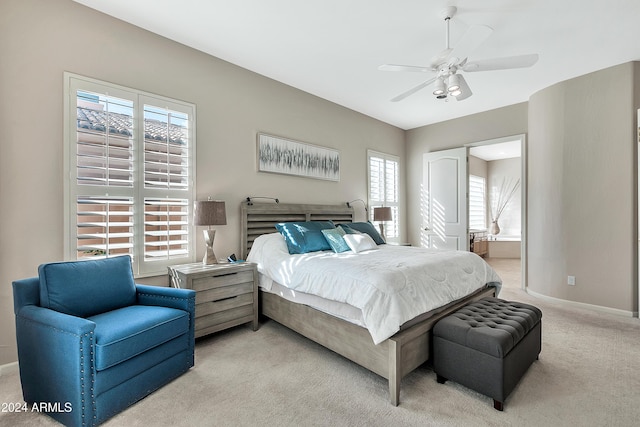 bedroom with light carpet, ceiling fan, and connected bathroom