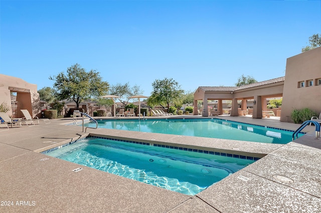 view of pool with a patio area and a hot tub