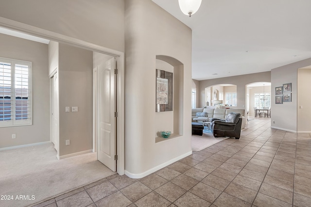 hallway featuring light tile patterned floors and a healthy amount of sunlight