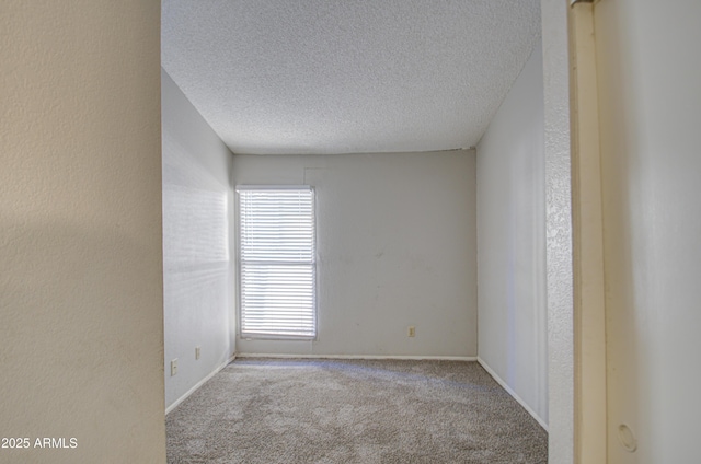 carpeted spare room featuring a textured ceiling