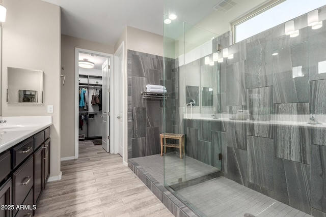 bathroom featuring vanity, tiled shower, and hardwood / wood-style floors