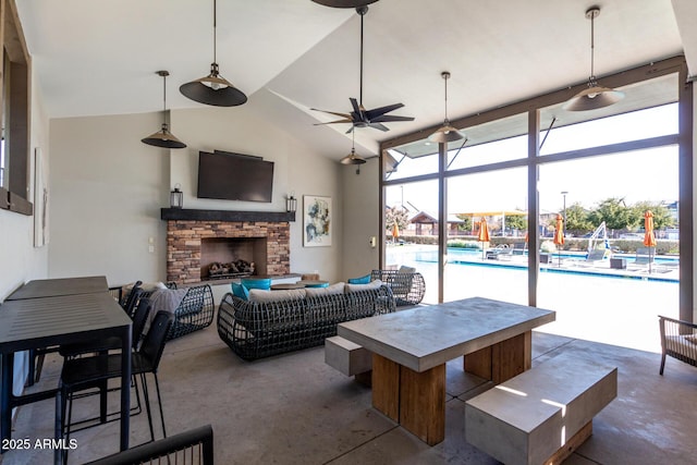 living room featuring a fireplace, vaulted ceiling, and concrete floors